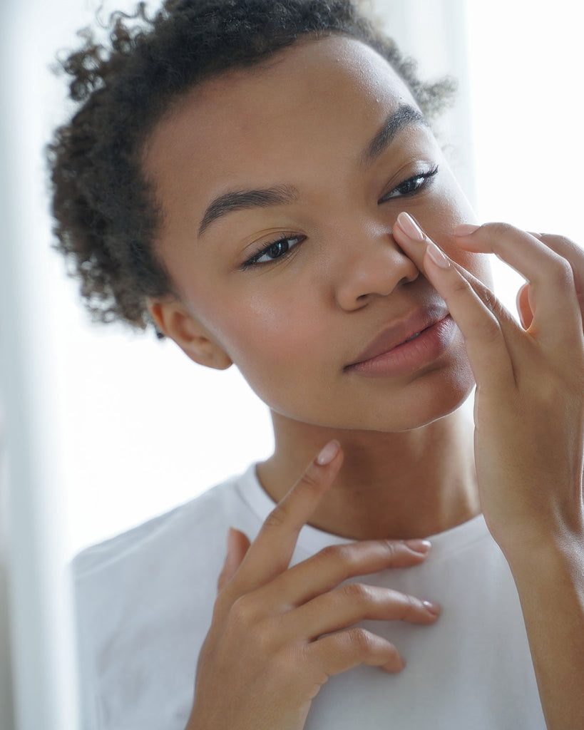 Afro girl applying cream to her face, showcasing Rosemira Skincare usage